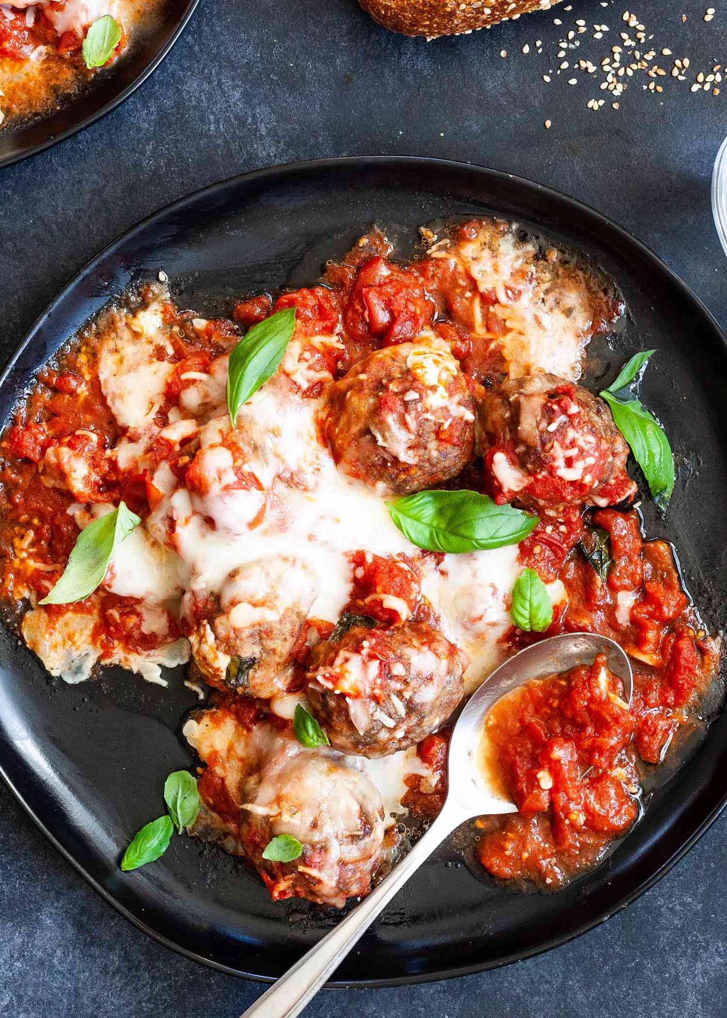 Mozzarella-stuffed meatballs with sauce on a plate with a spoon