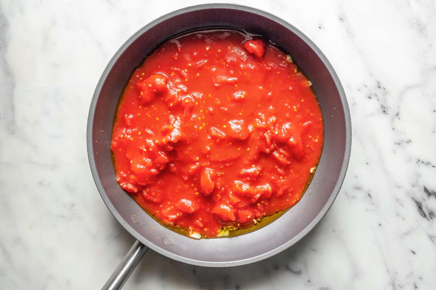 Canned Tomatoes Added to Skillet for Stuffed Shells Casserole