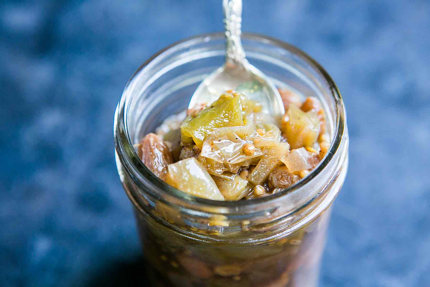 green tomato chutney in a mason jar with a spoon