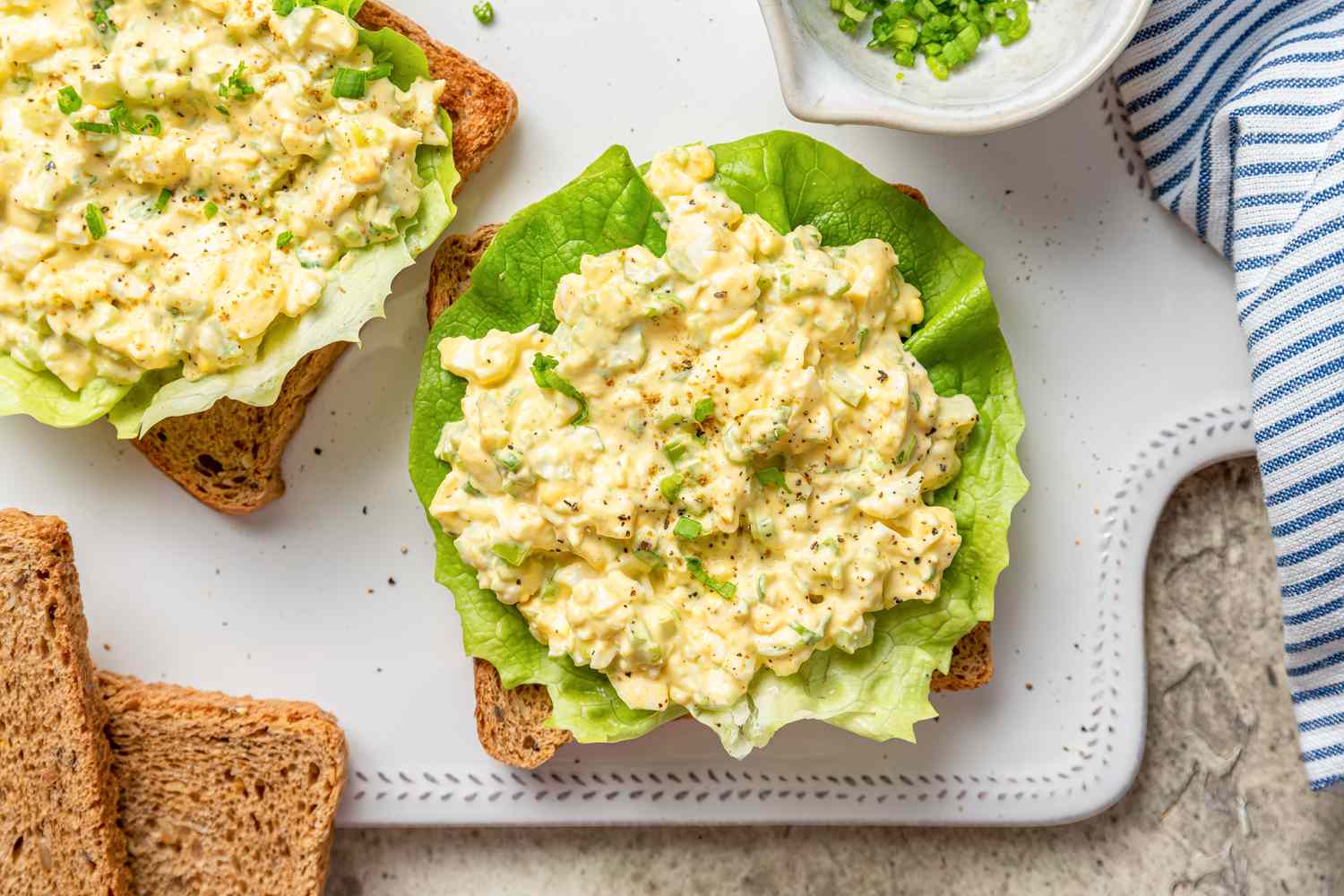 egg salad sandwich being made on a cutting board