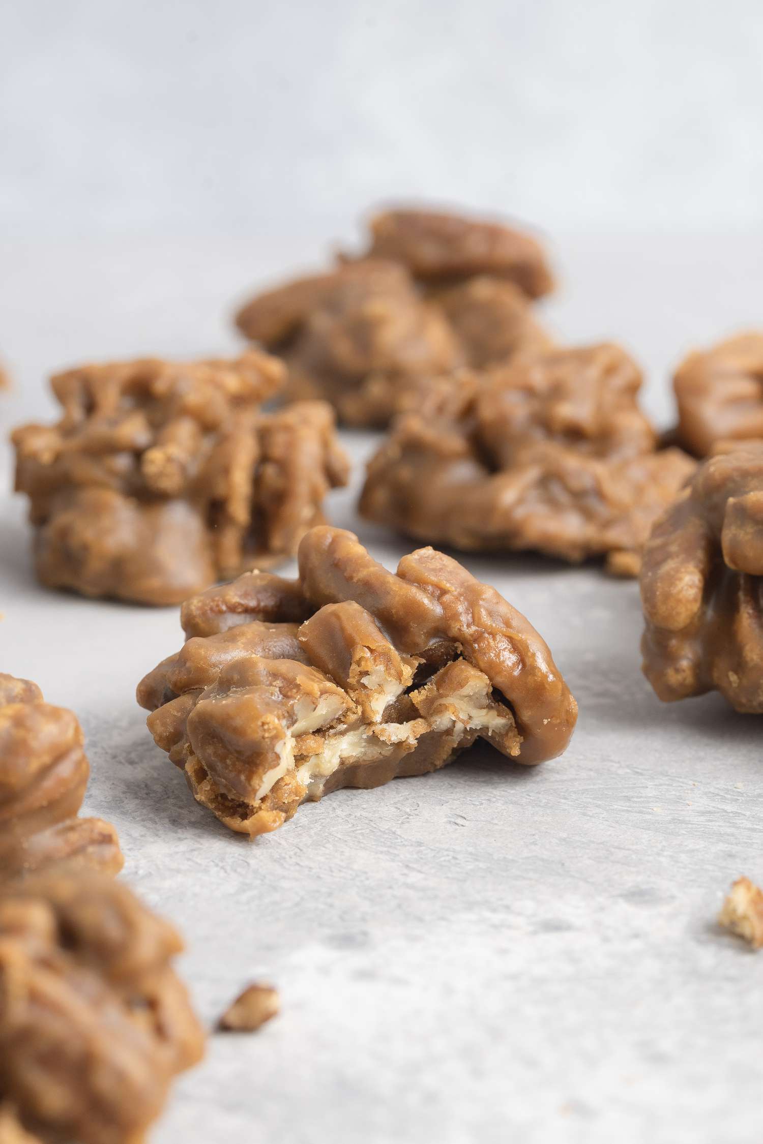Southern pralines on parchment paper with a bite taken out of the middle one.
