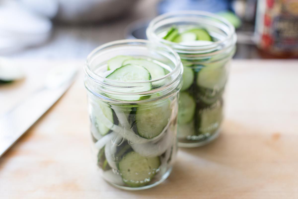 Pack the sliced cucumbers and onions into canning jars for refrigerator pickles