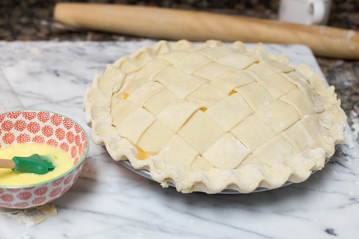 Peach pie with a lattice top crust ready for the oven