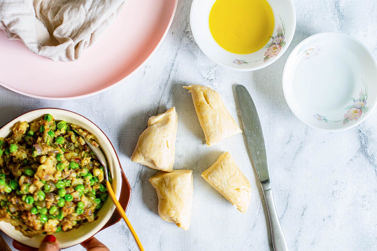 Samosa dough, vegetable filling, ghee, and a pink plate.