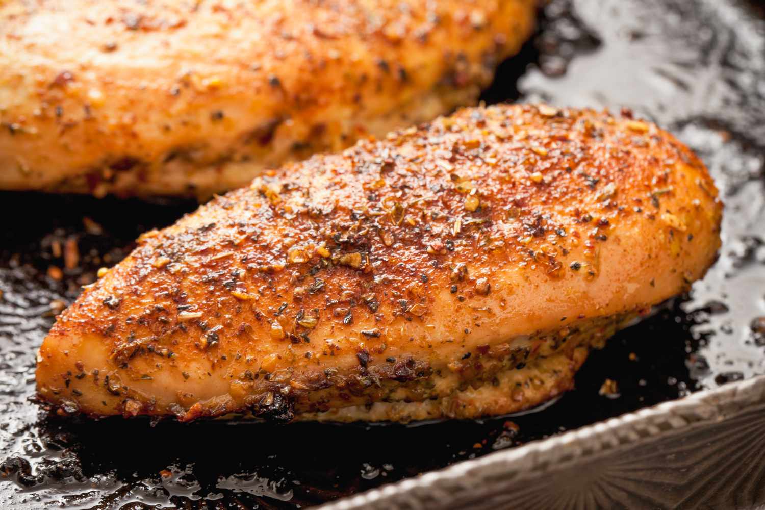 Grilled Boneless Chicken breasts, in metal baking pan.