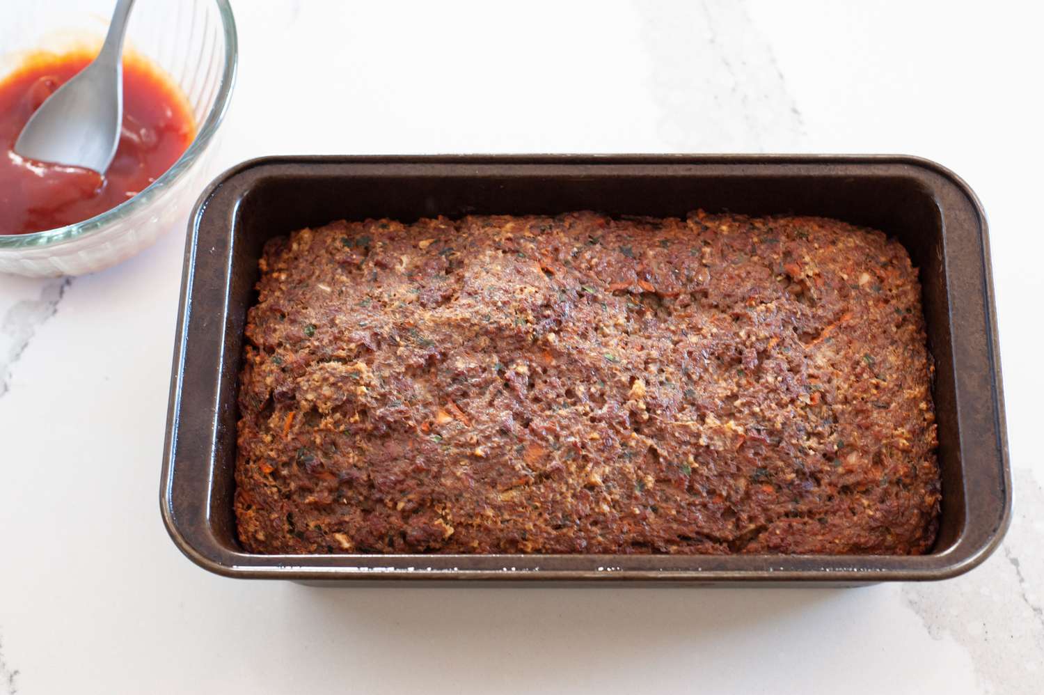 Vegetarian Meatloaf (Cooked) Next to Bowl with Sauce