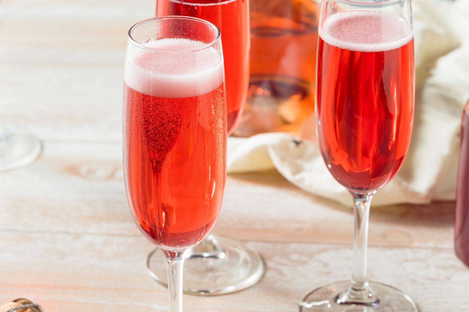 a red bubbly cocktail in a champagne glass