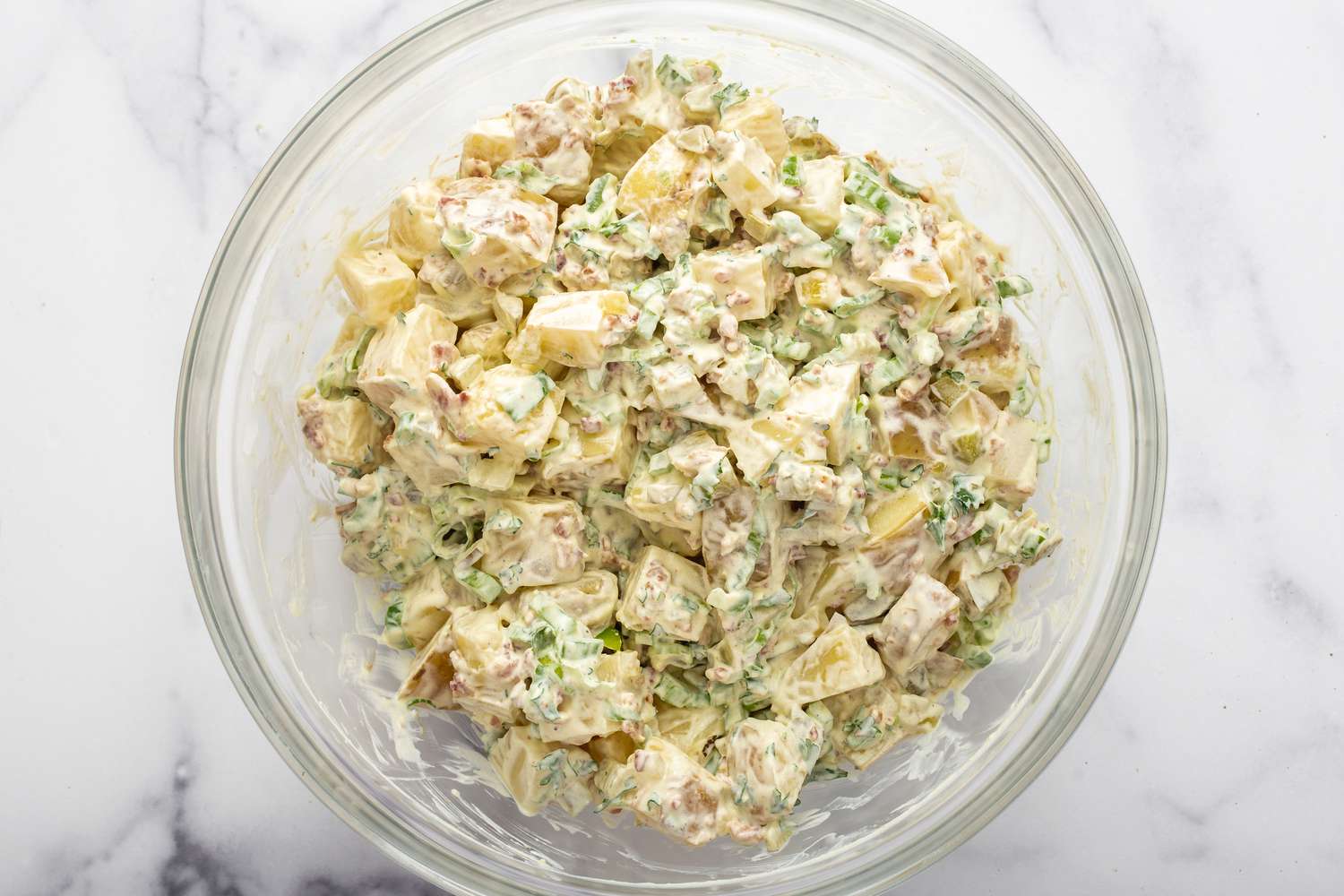 A glass bowl of homemade potato salad.