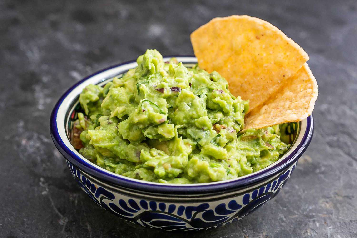 Authentic guacamole in a bowl with chips