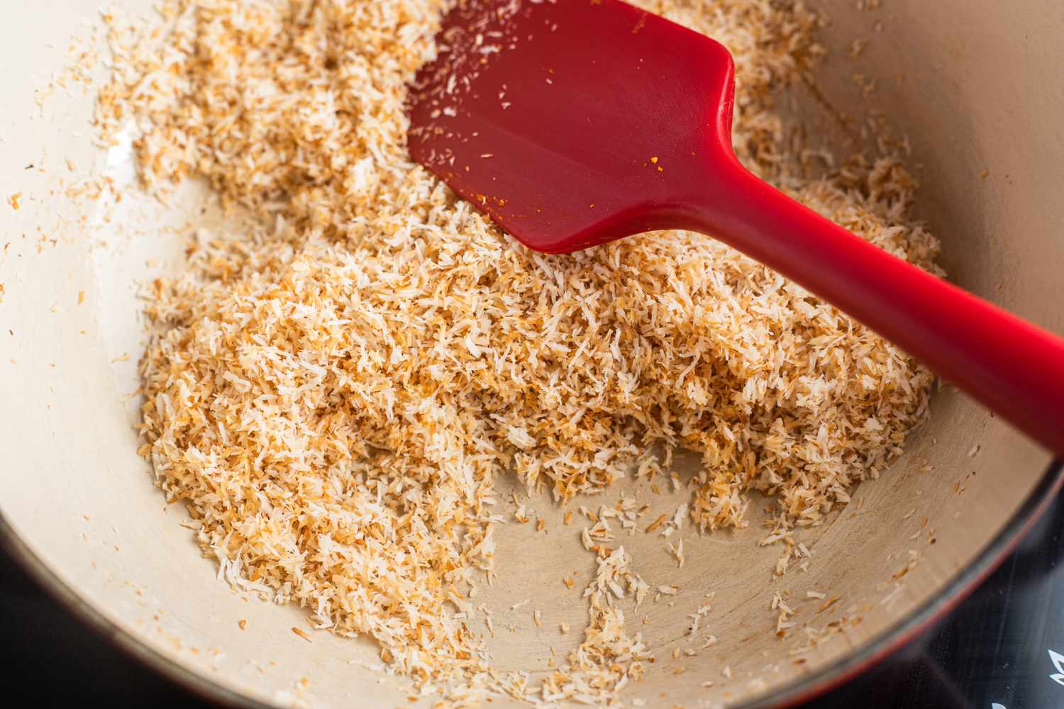 Shredded Coconut Toasted on Skillet for Pumpkin Ladoos Recipe 