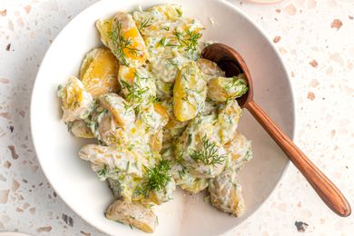 tzatziki potato salad in a bowl with a serving spoon