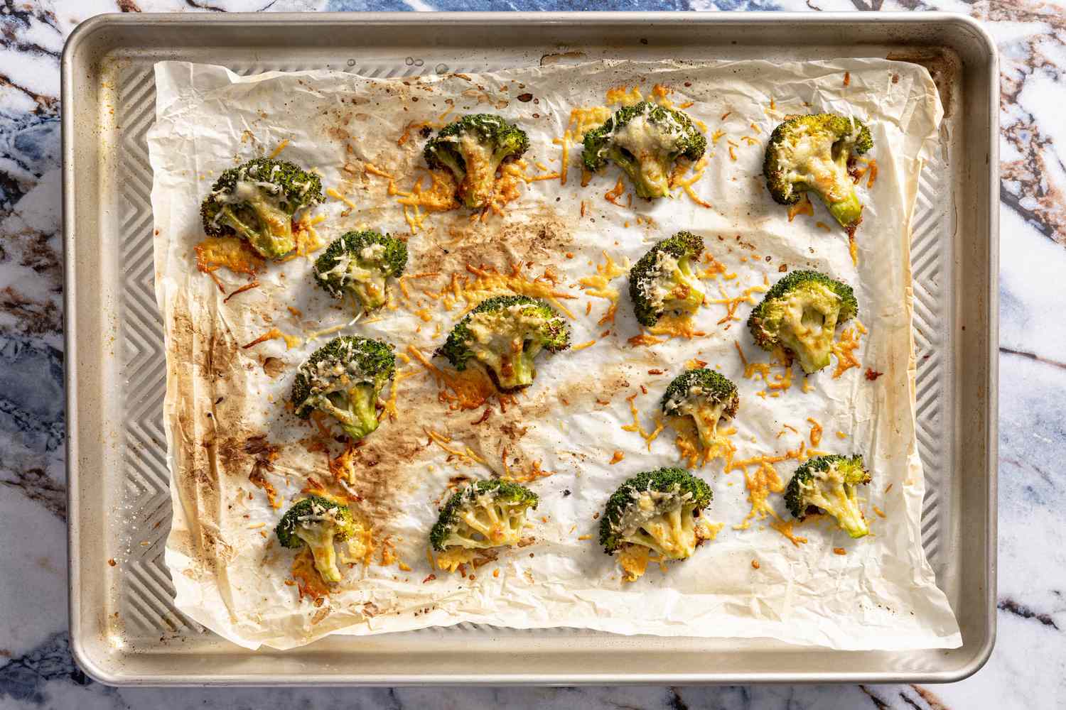 crispy parmesan broccoli on parchment paper on a baking tray