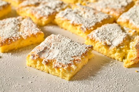 Squares of powdered sugar topped bar dessert arranged closely