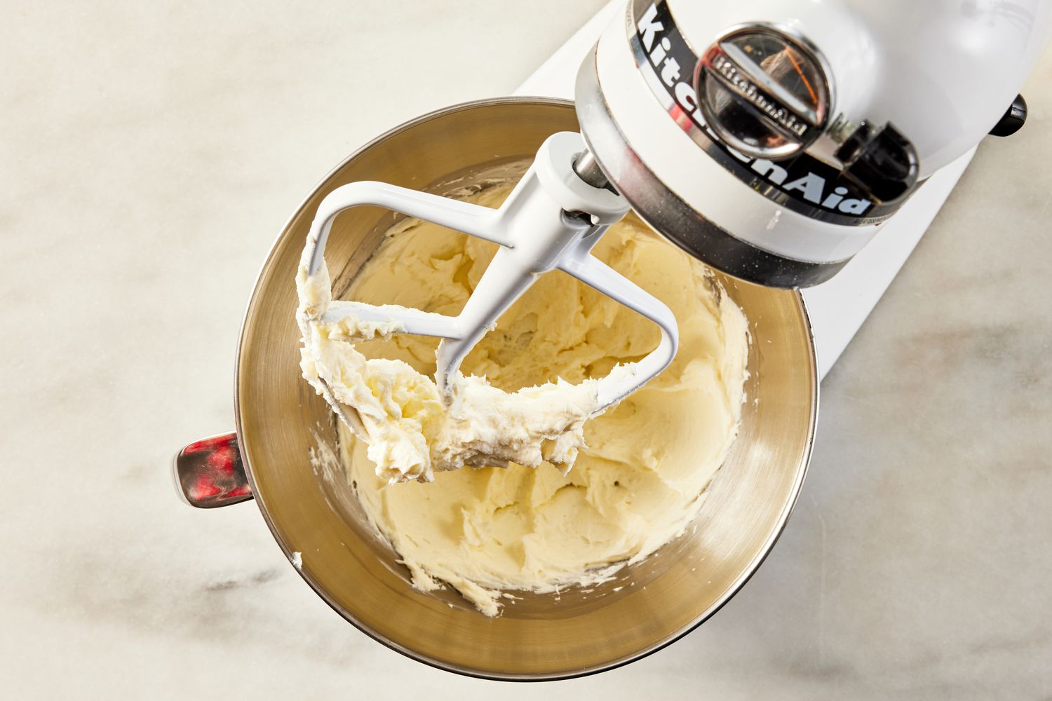 buttercream icing in a mixing bowl for pink lemonade cake recipe