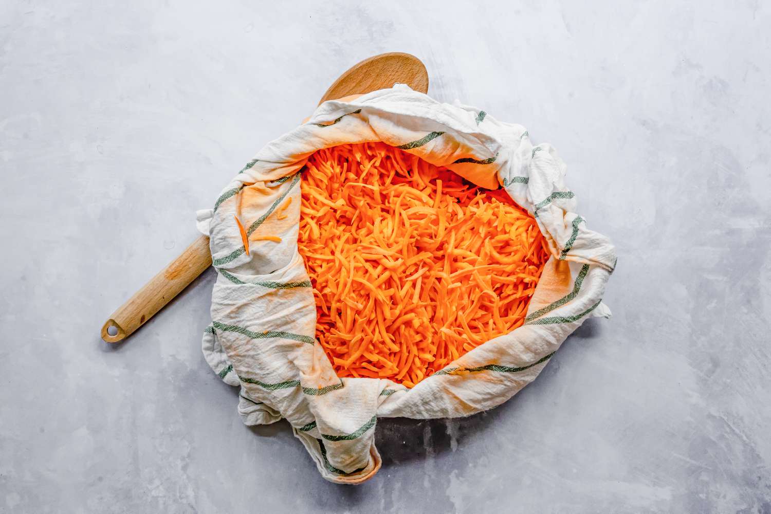 Liquid Wrung from Sweet Potatoes and Onions Using a Kitchen Towel for Latkes Recipe
