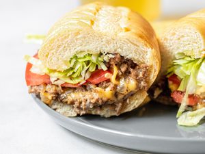 Two Halves of a Chopped Cheese Sandwich on a Plate 