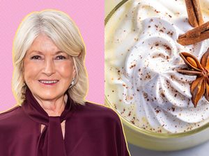 Martha Stewart next to a glass of eggnog topped with whipped cream and spices