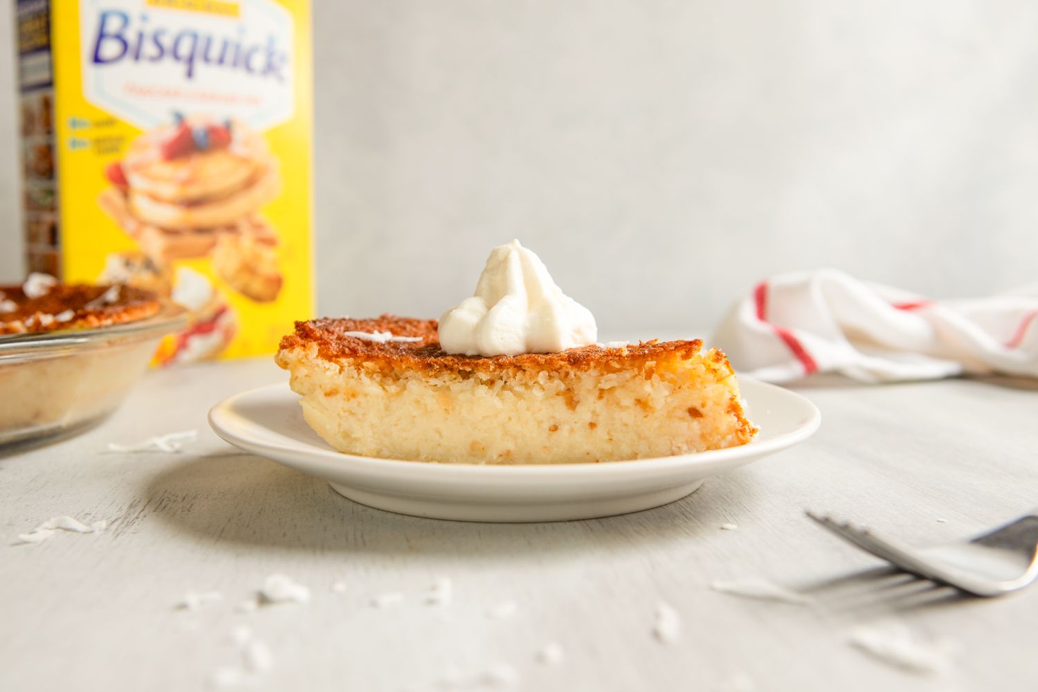 Slice of pie on a plate with whipped topping Bisquick box in the background