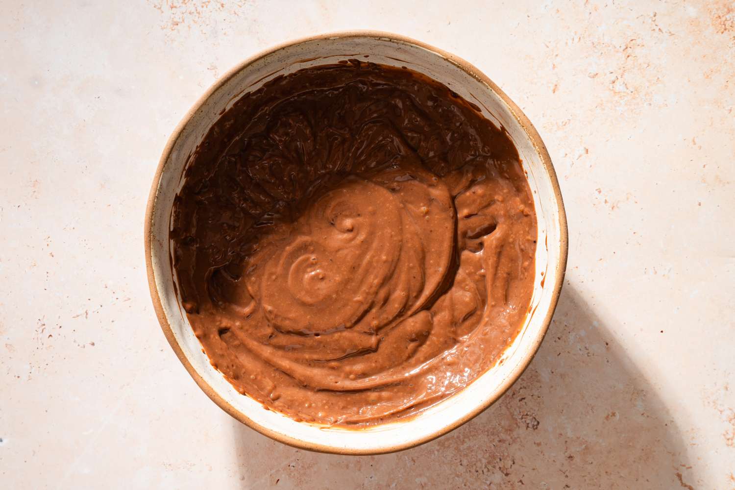 Overhead view of a bowl of mixed milk and pudding mix for Chocolate Delight recipe