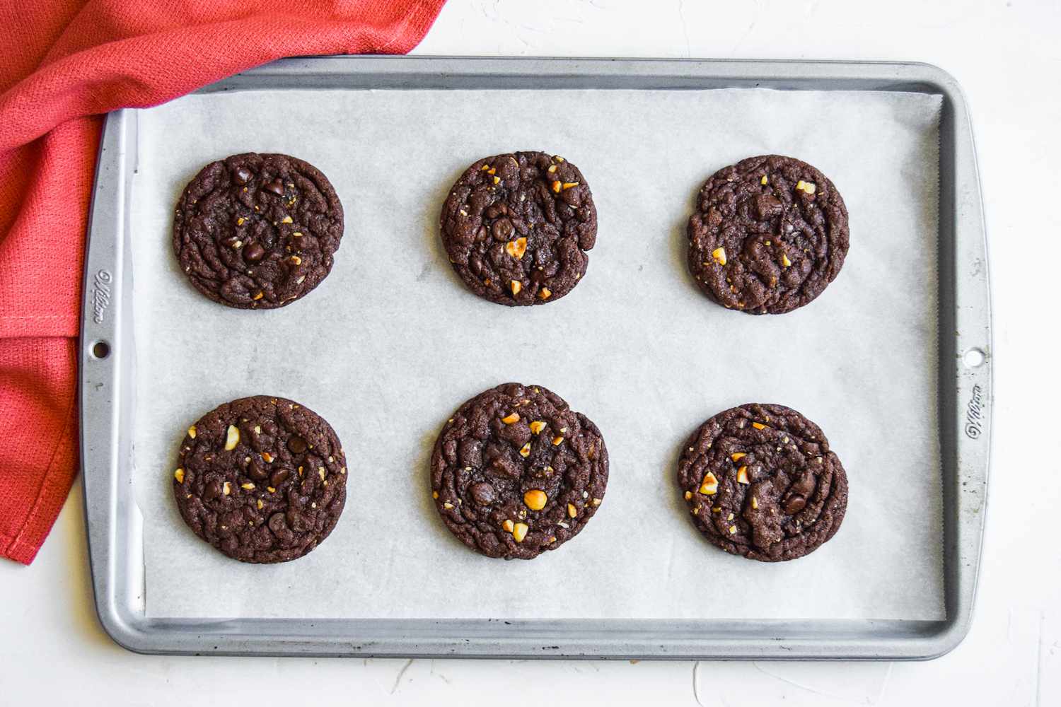 Overhead view of a baking sheet with chocolate cookies on it.