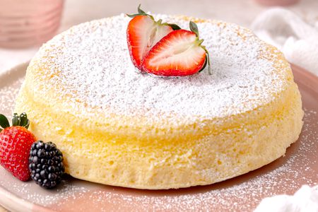 Japanese Cheesecake on a Plate and Garnished With Powdered Sugar and Berries