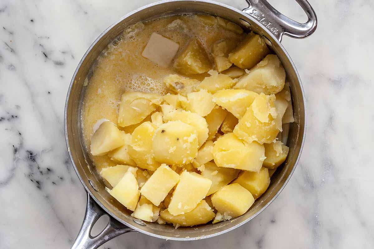 Easy Vegetarian Cottage Pie - silver pot with cut up cooked potatoes