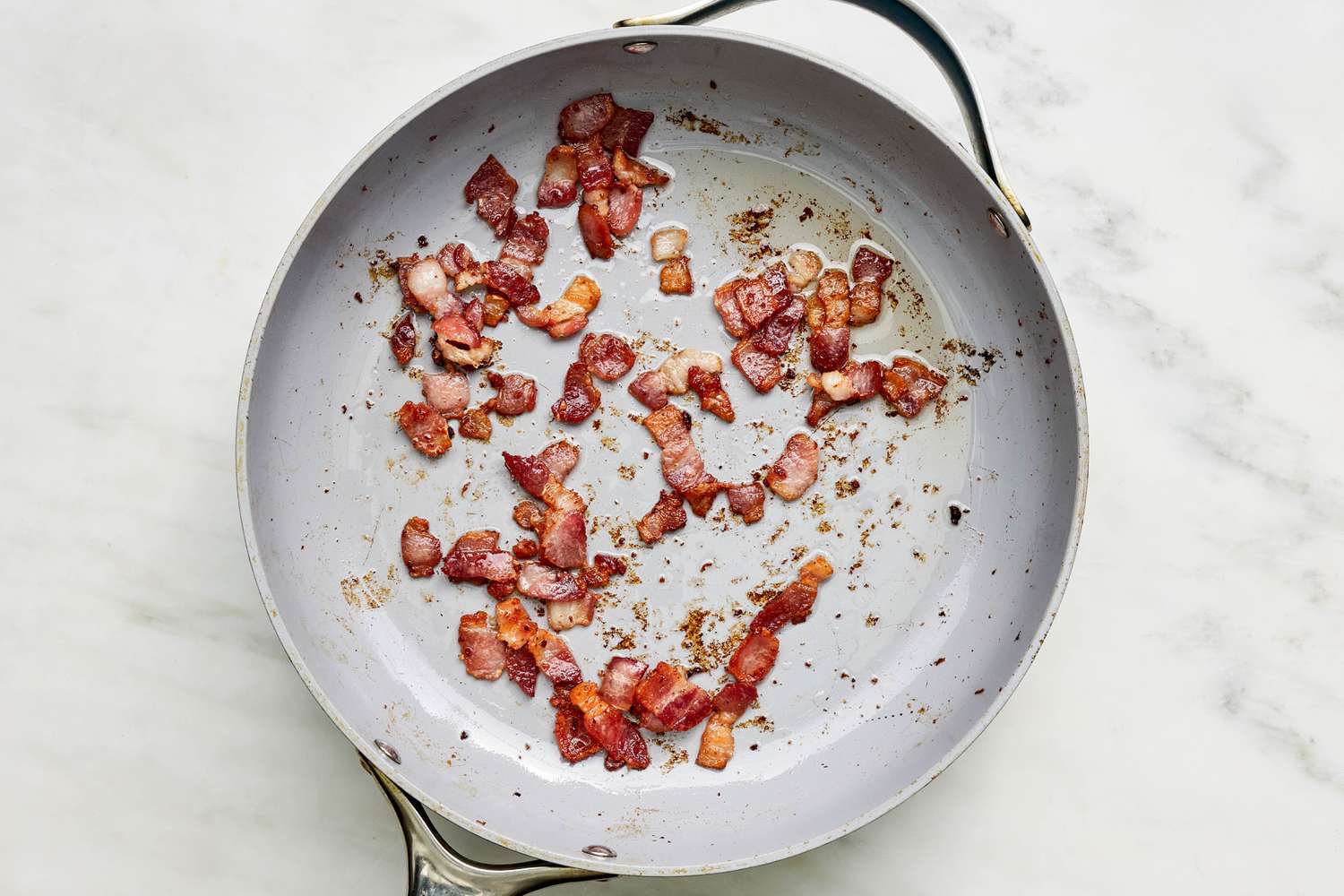 Sliced bacon cooked in a skillet for Creamy Skillet Gnocchi With Bacon and Peas recipe