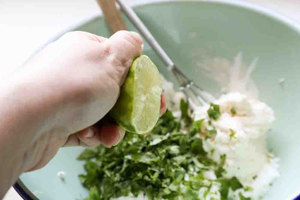 Squeezing the lime for the crema topping for mexican street corn