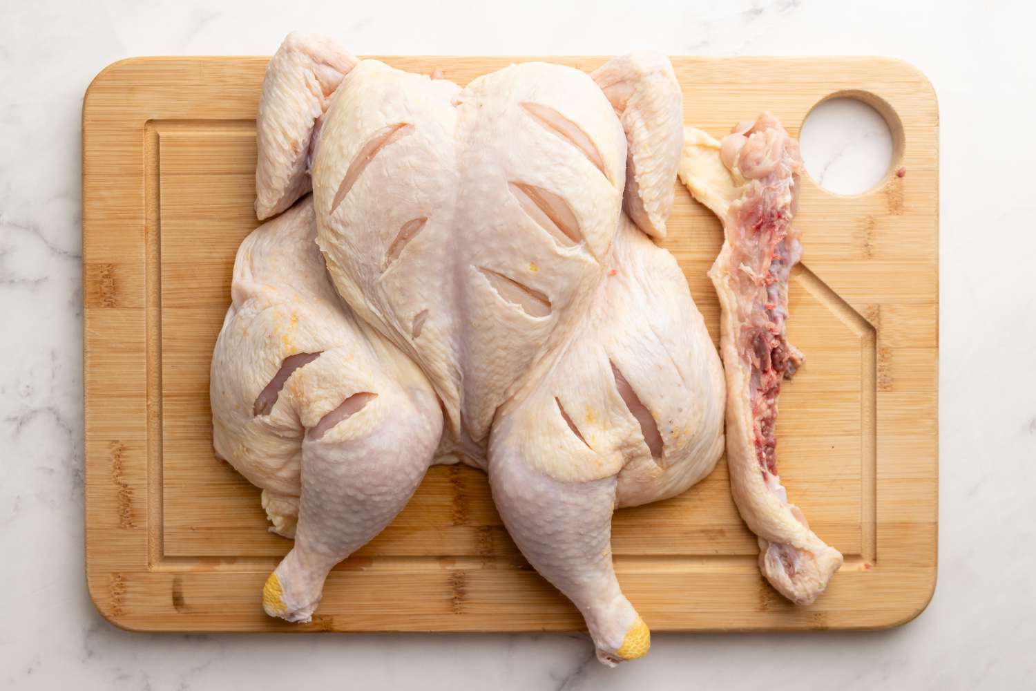 Spatchcock Chicken on Cutting Board for Smoked Spatchcock Chicken with Harissa Butter and Grilled Carrots