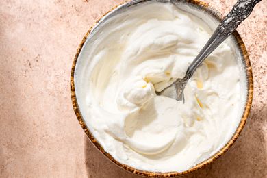 A bowl of whipped cream with a spoon in it