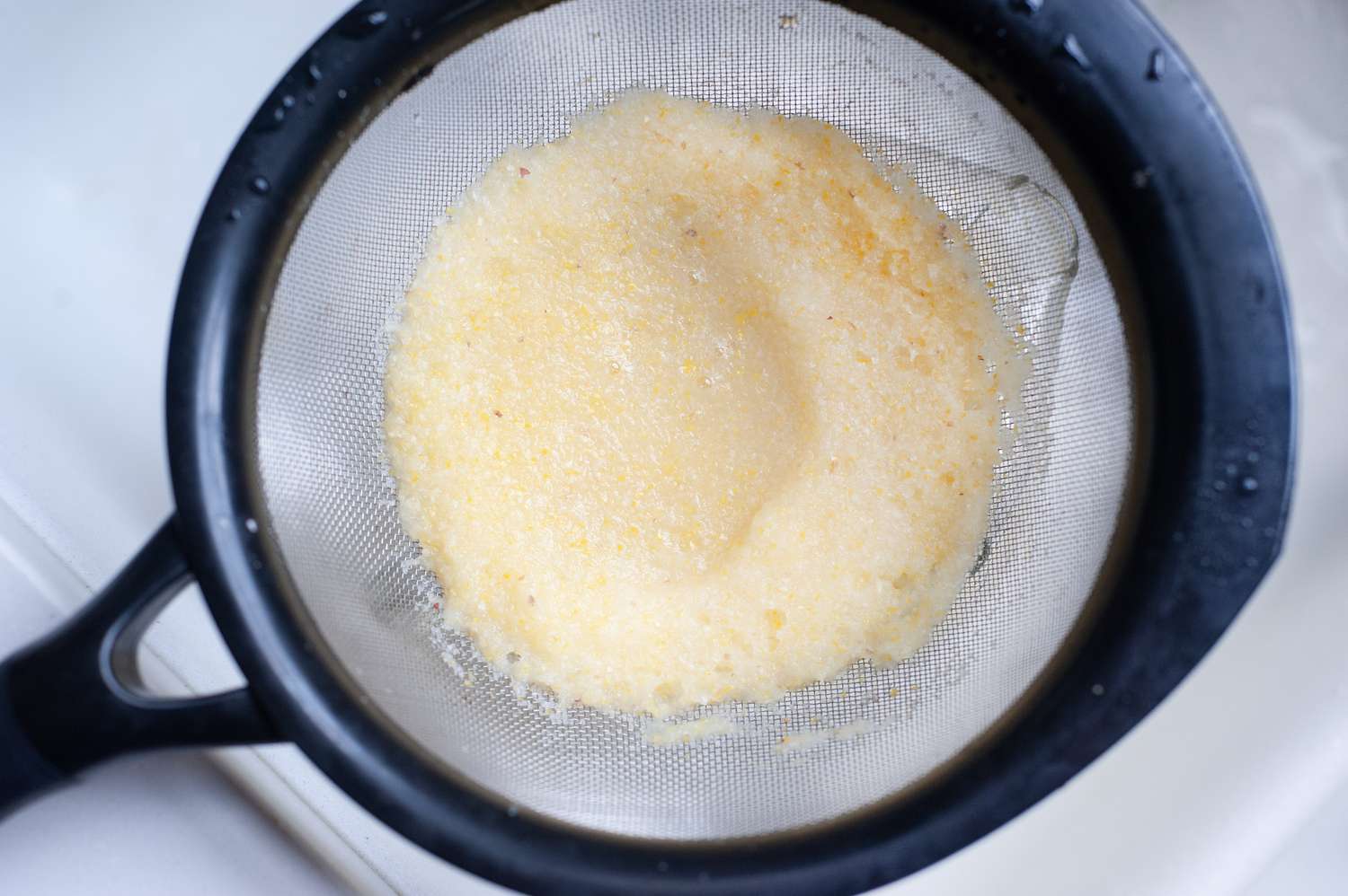 How to make whole lemon lemonade by straining in a fine-mesh sieve.