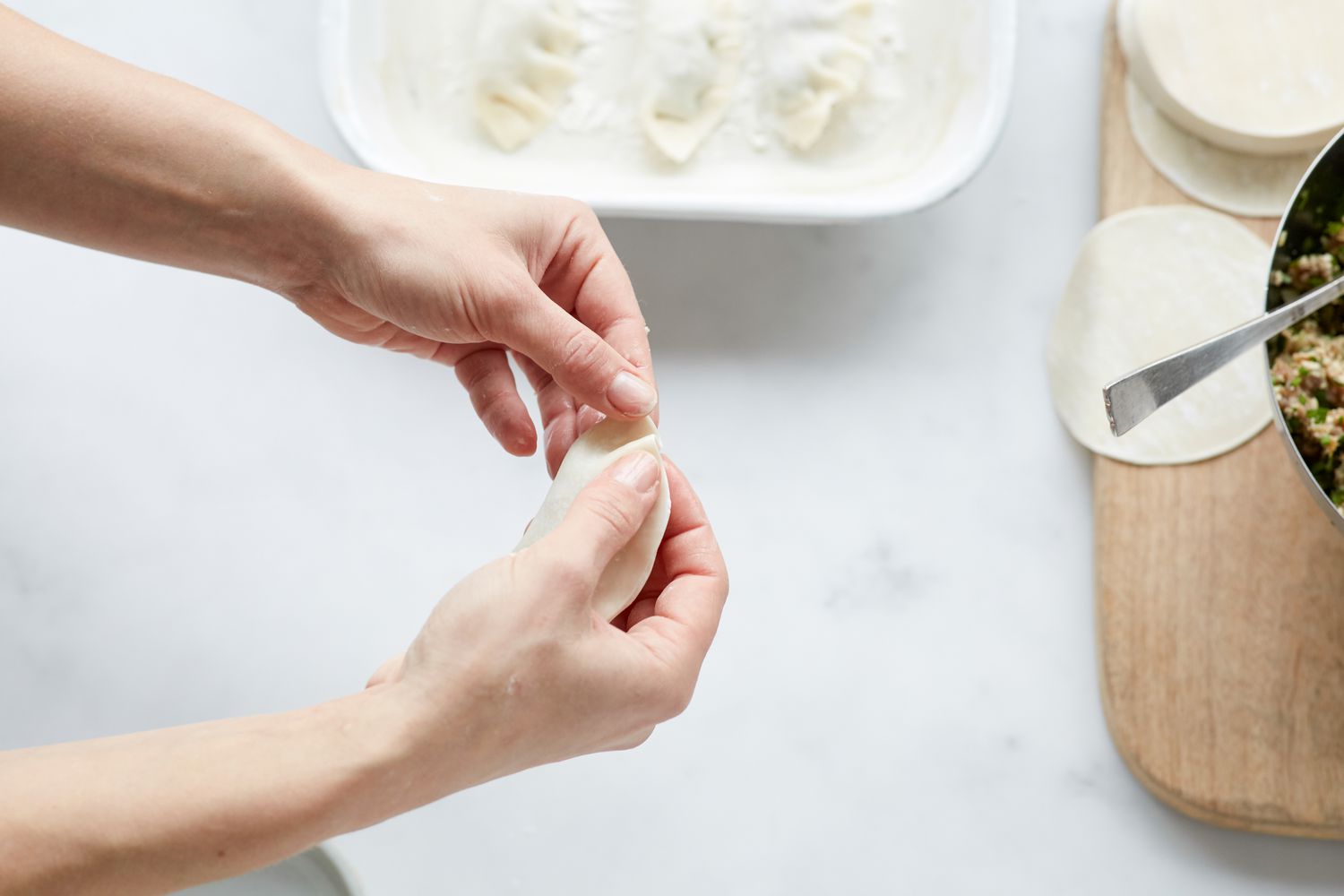Filling and folding Korean pork and chives dumplings 