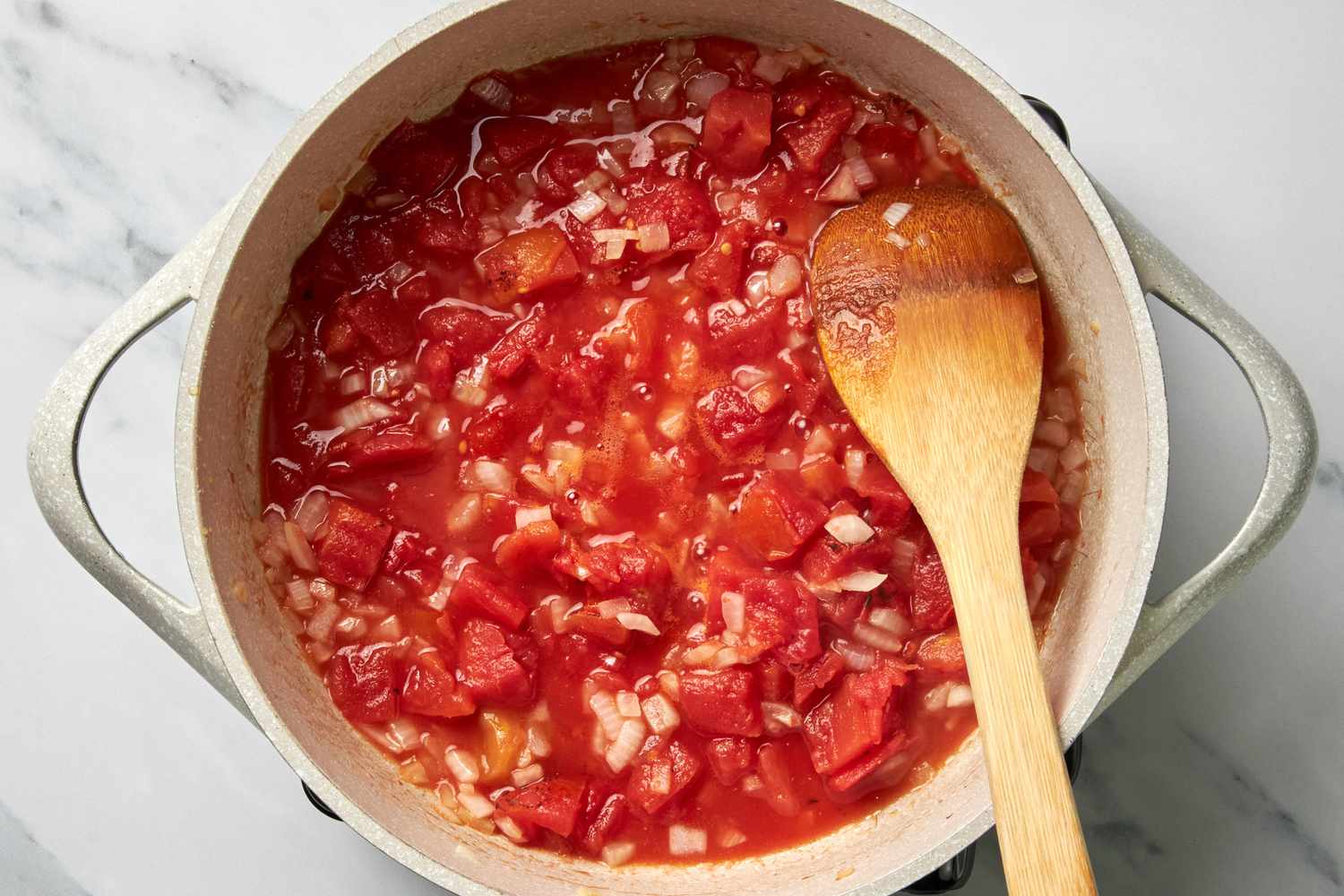 Pot of Salsa Ingredients Mixed With a Wooden Spoon