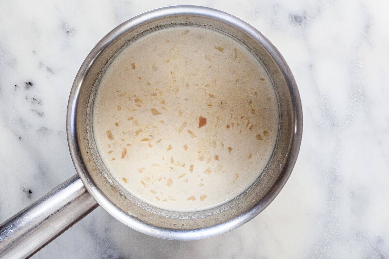 Cream added to shallots for classic buerre blanc sauce