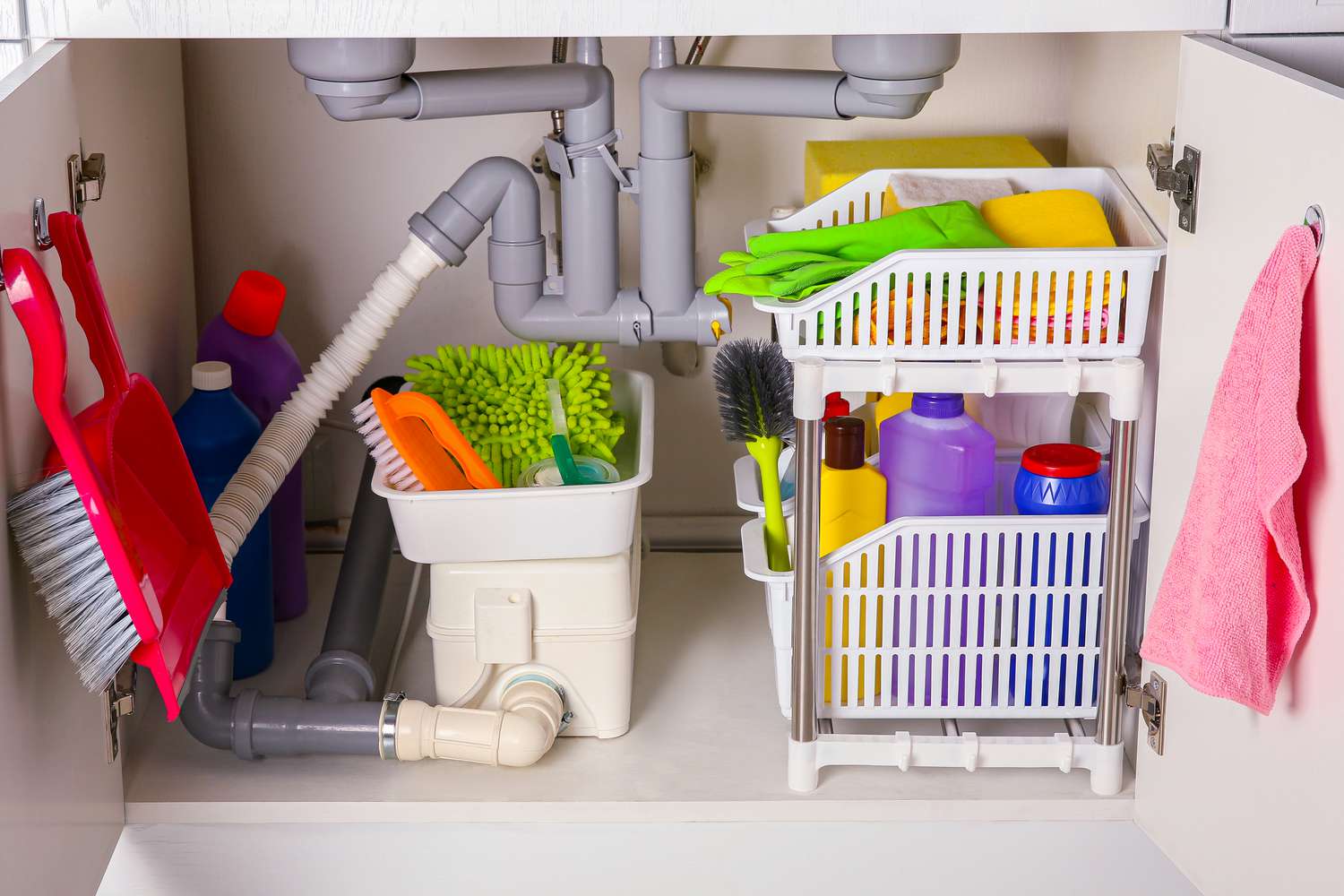Cleaning tools and supplies in open cabinet under a kitchen sink