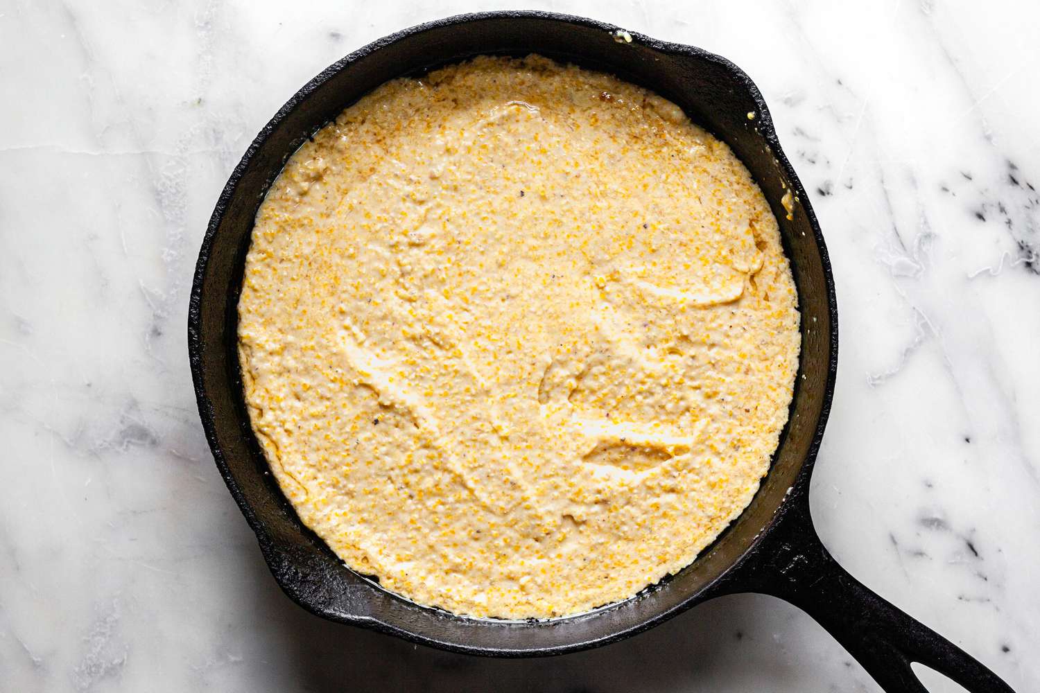 Southern Cornbread Batter Added to Cast Iron Skillet