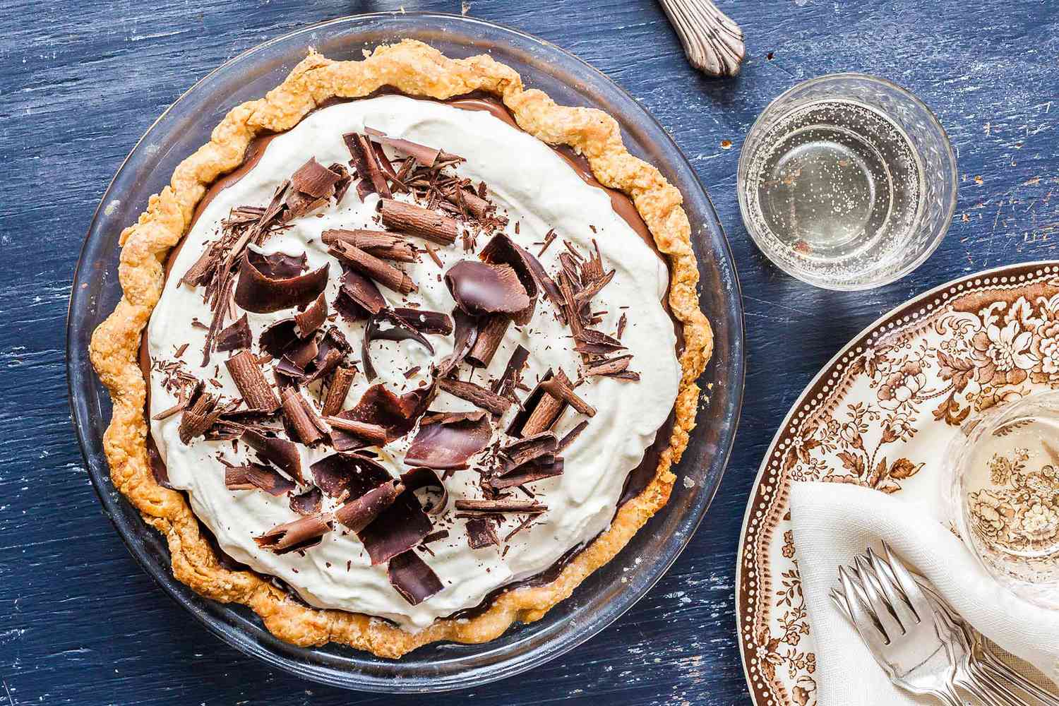A whole chocolate pie topped with shaved chocolate.