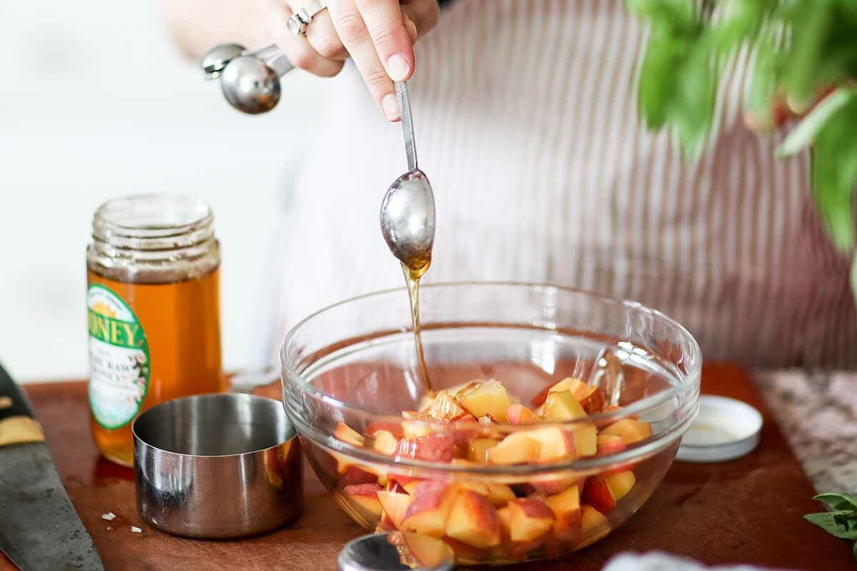 Salad recipe with peaches, goat cheese, and pistachios toss the peaches with honey