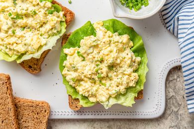 egg salad sandwich being made on a cutting board