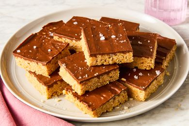 Angled view of sliced squares of Scotcheroos stacked on a plate