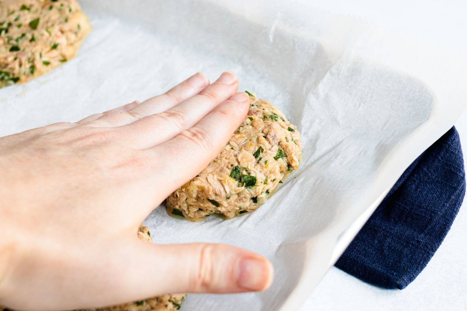 Flattening the tuna cake mixture for a tuna cake recipe.