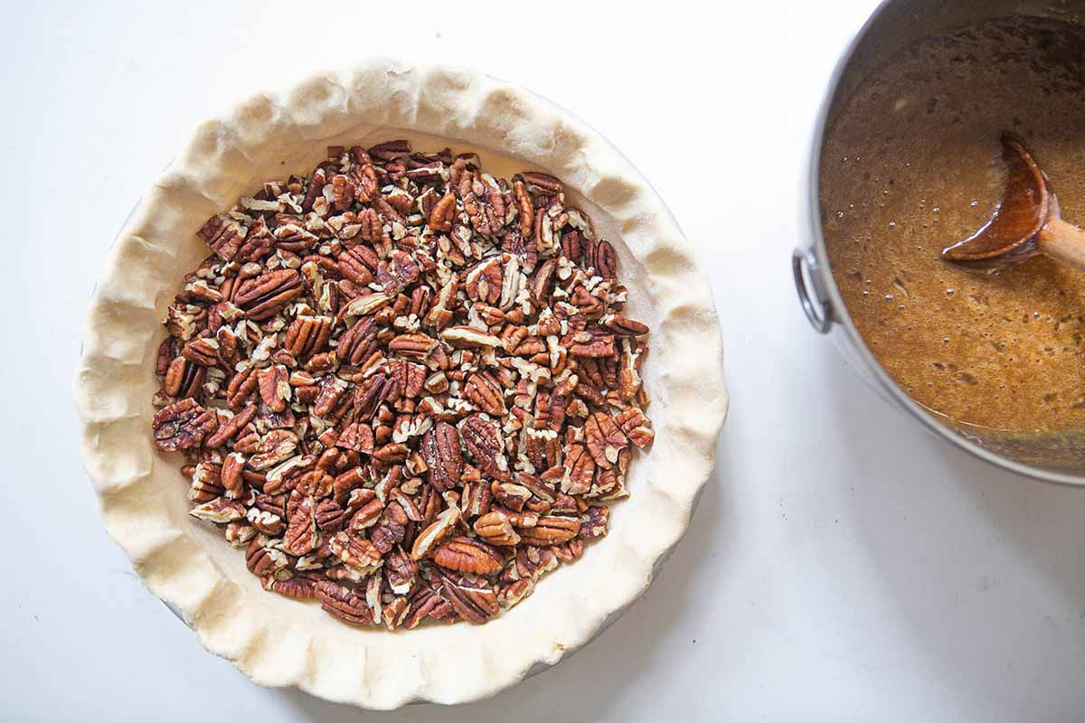 A pie crust filled with chopped pecans 