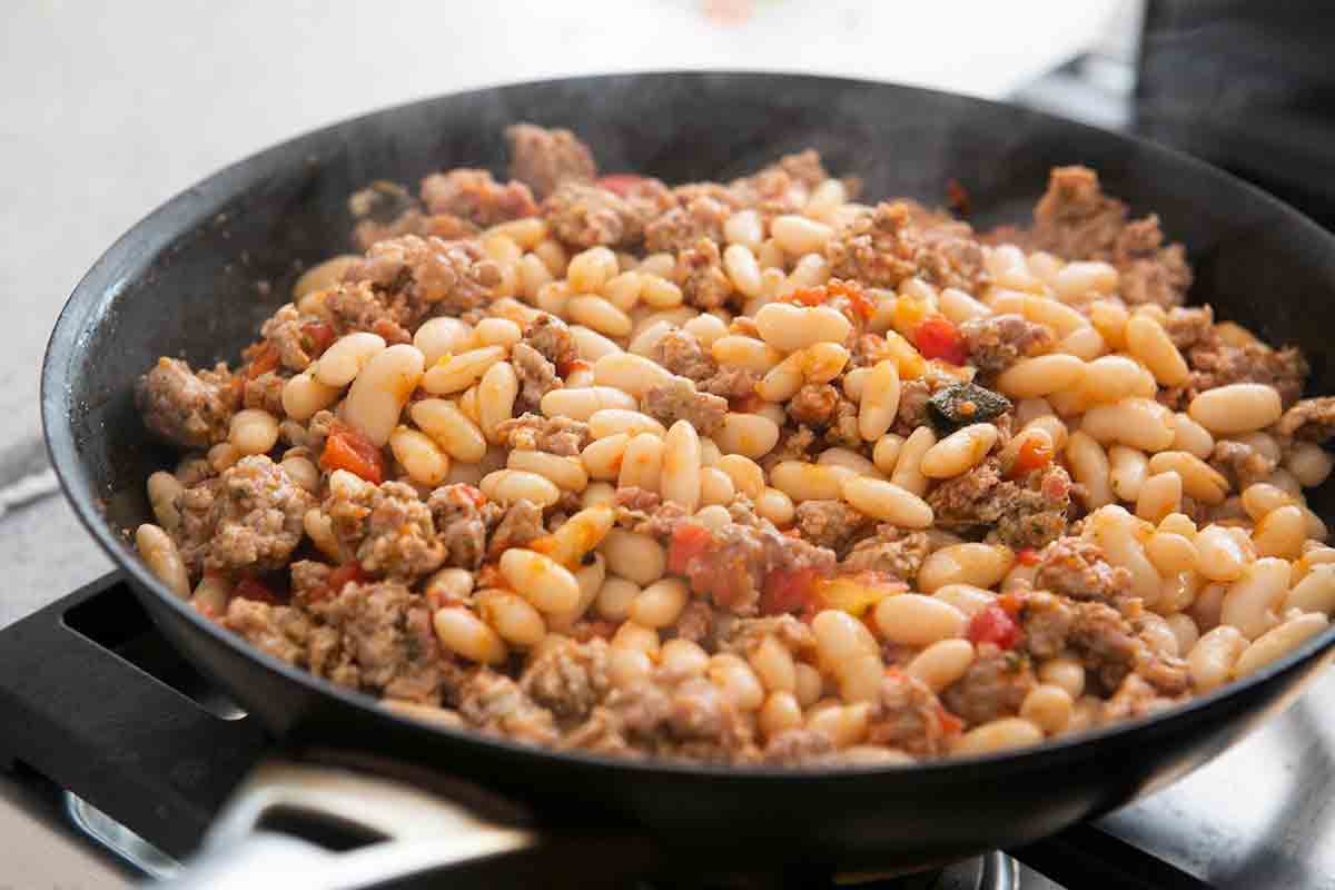 add white beans to sausage in pan