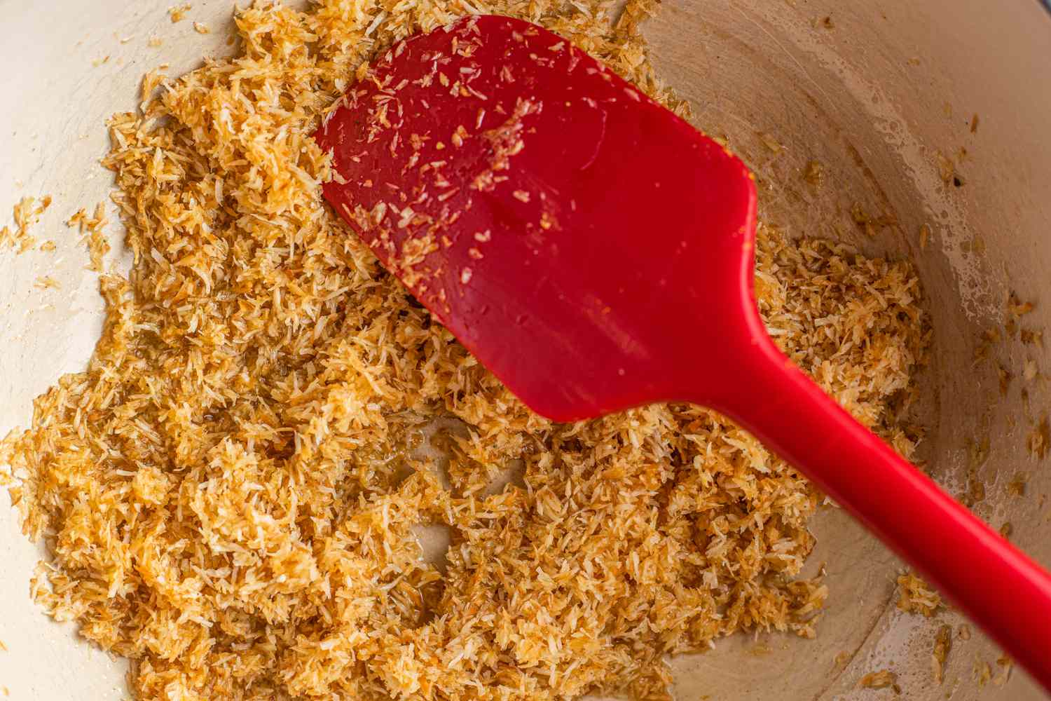 Ghee Added to Toasted Coconut in Skillet for Ladoo Recipe