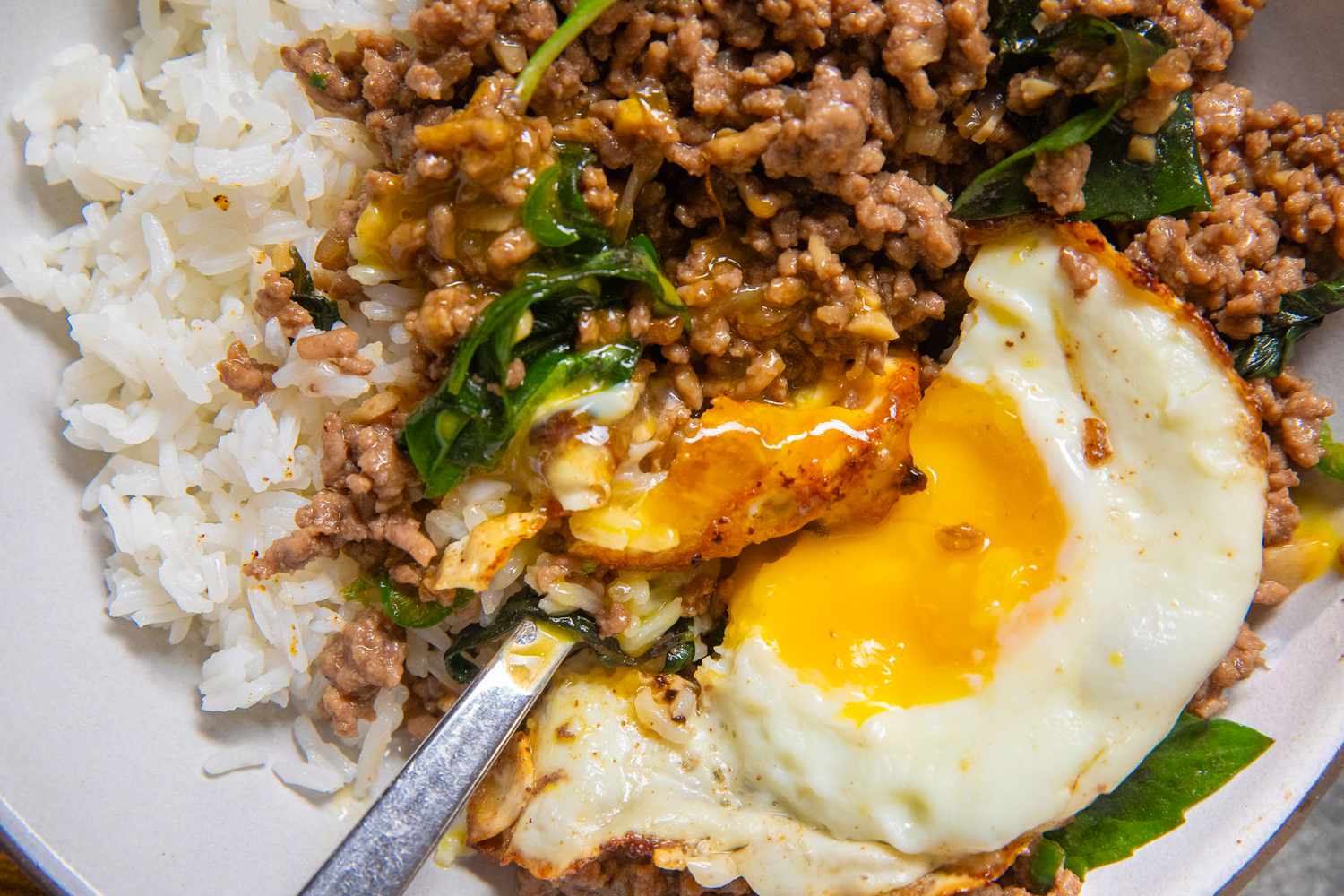close up of a bowl of Beef Krapow bowl with a fried egg