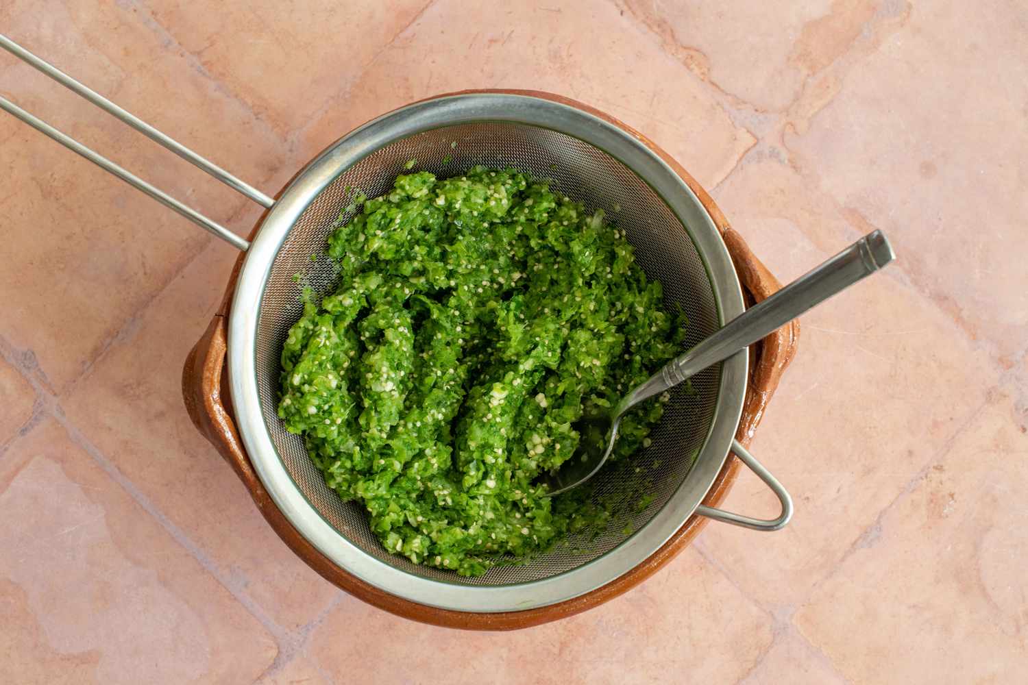 Chile Verde Strained Using a Colander and Pressed with a Spoon