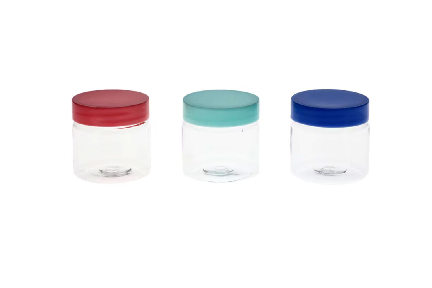 Three small glass jars with colorful lids in the front a white background