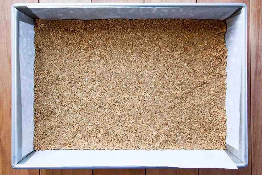 Graham cracker layer for magic bars pressed into the baking dish