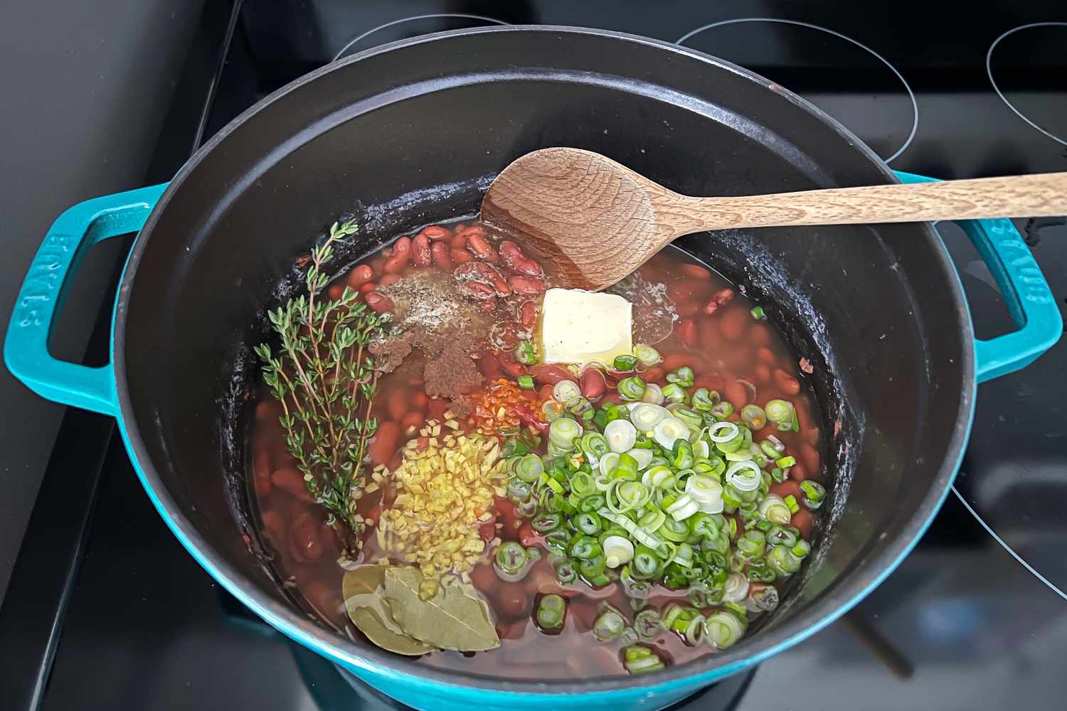 Add Scallions, Thyme, and Coconut Oil to Beans in Dutch Oven for Jamaican Rice and Peas
