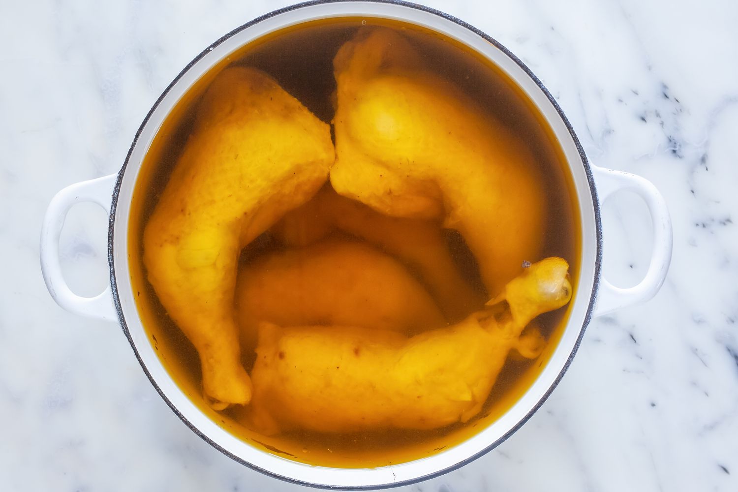 Chicken confit in white dutch oven.